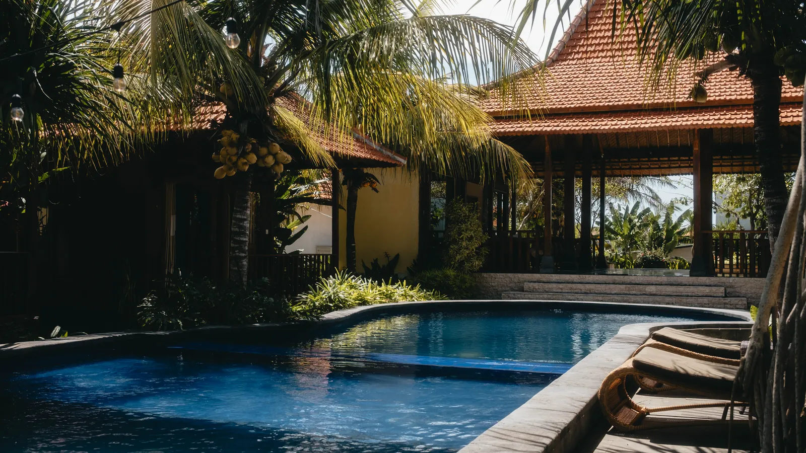 A pool beside a thatched Balinese pavilion