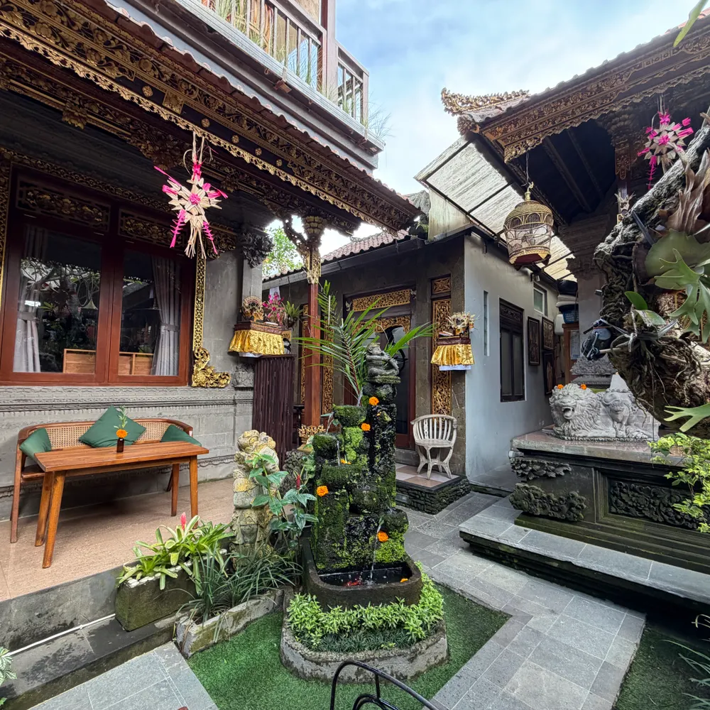 A Balinese family courtyard with carved doors and plants
