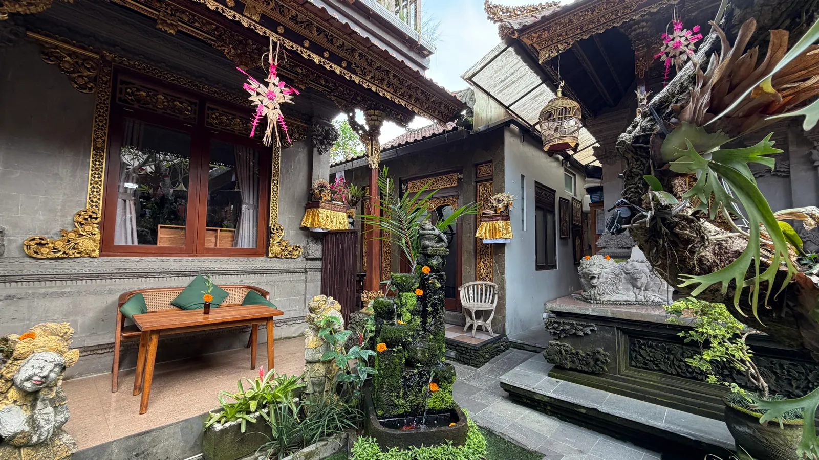 A Balinese family courtyard with carved doors and plants
