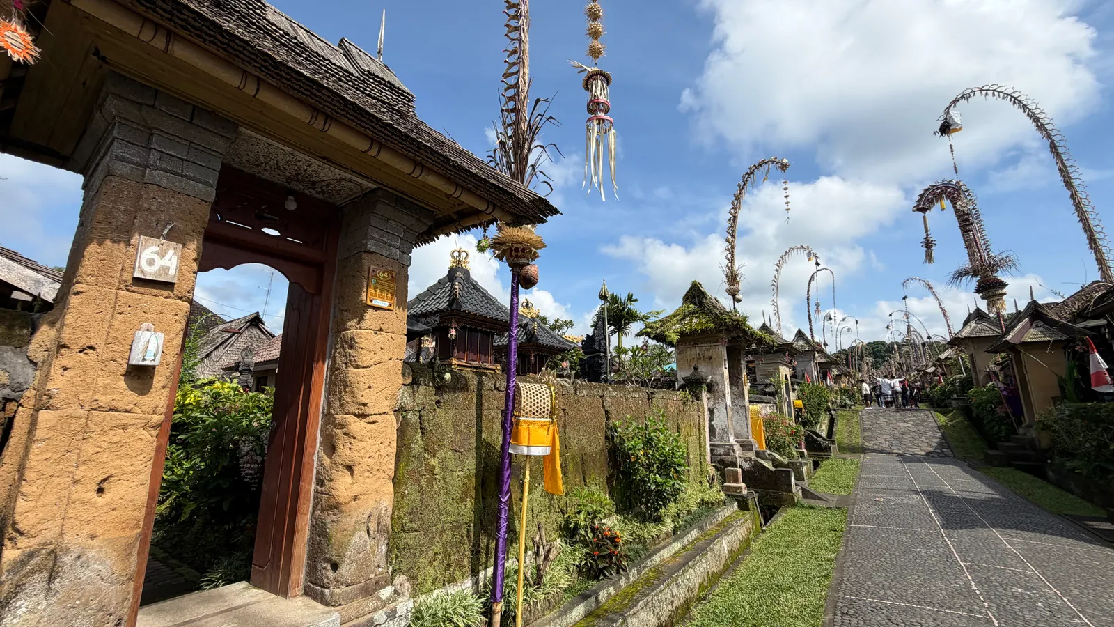 A quiet village lane lined with Balinese gates